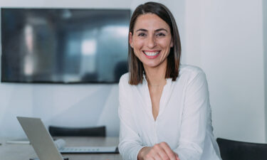 business woman smiling at desk